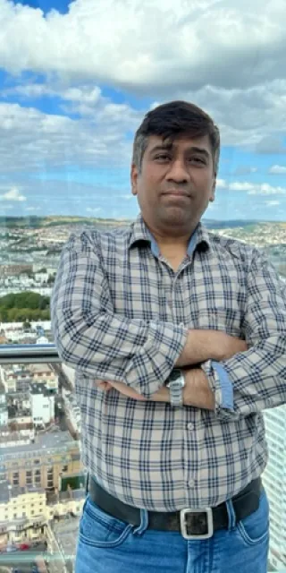 Center alumni Amit Kumar Chouhan looking into the camera with a city view in the background