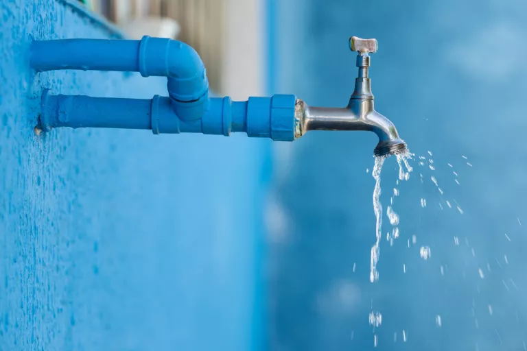 Stock image of water dripping from a tap in the wall