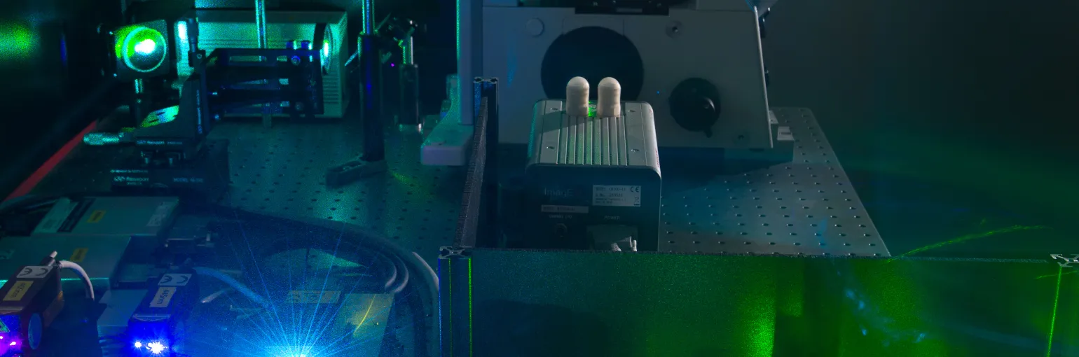 Blue and green laser lights from lab equipment from the Light Microscopy unit.