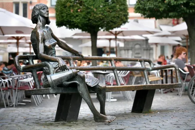 The Kotmadam statue in Leuven of someone sitting on a functional bench